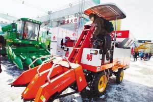 一家企业展出的新式农机引起外国客商的兴趣。 本报记者 陈南 摄
